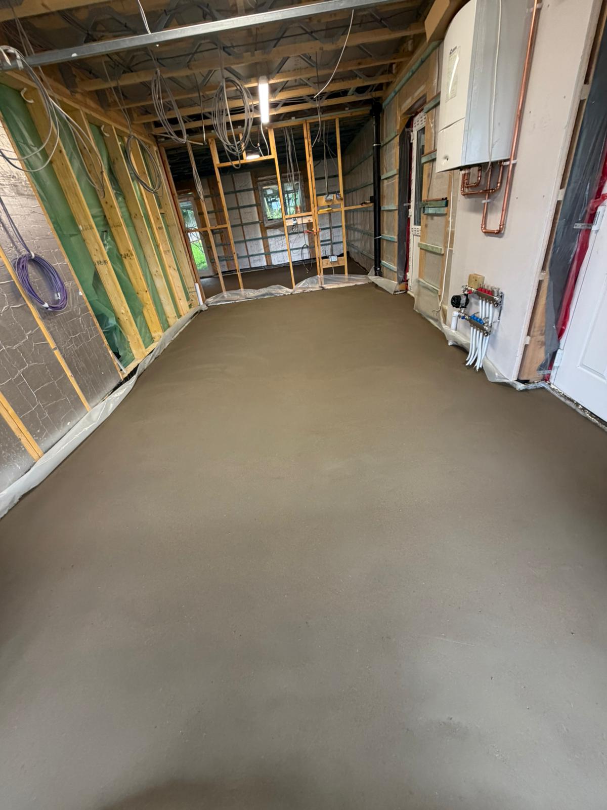 Screeded floor beside the underfloor heating manifold and the hot water cylinder