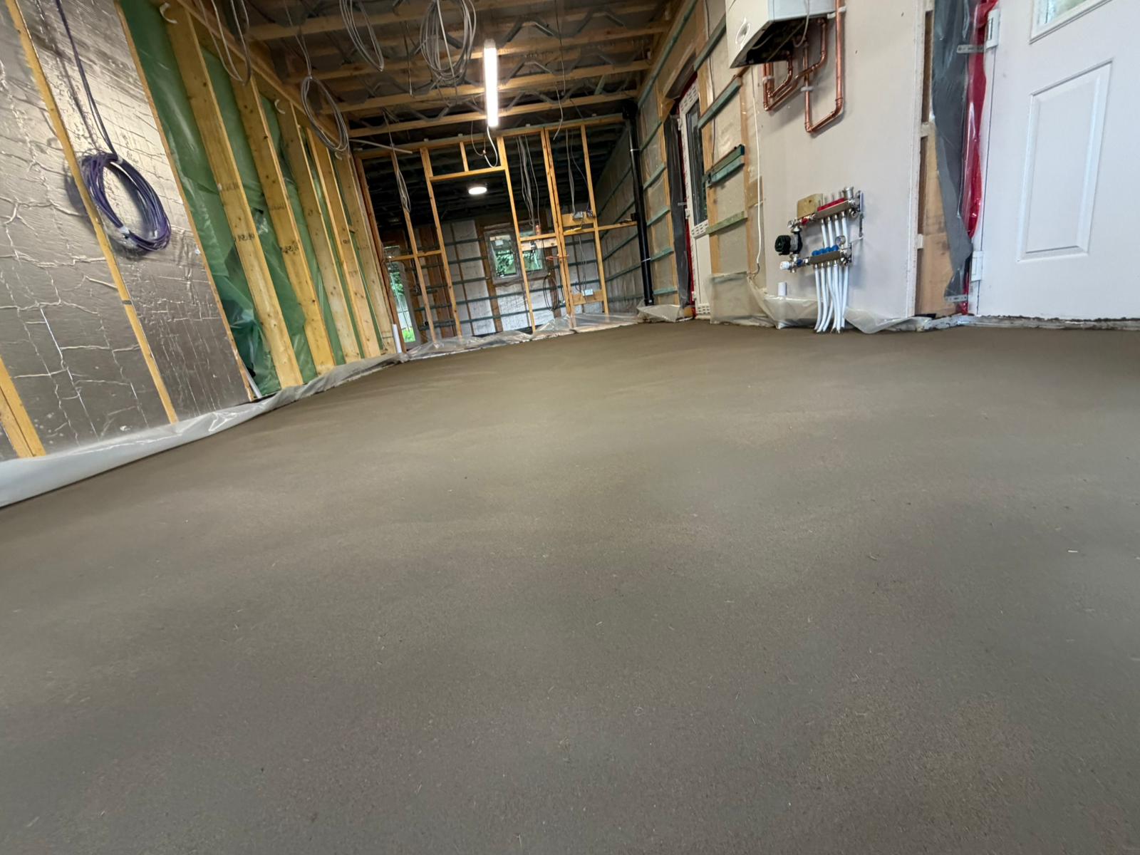 Low level view across the finished fibre screed floor towards the heating manifold