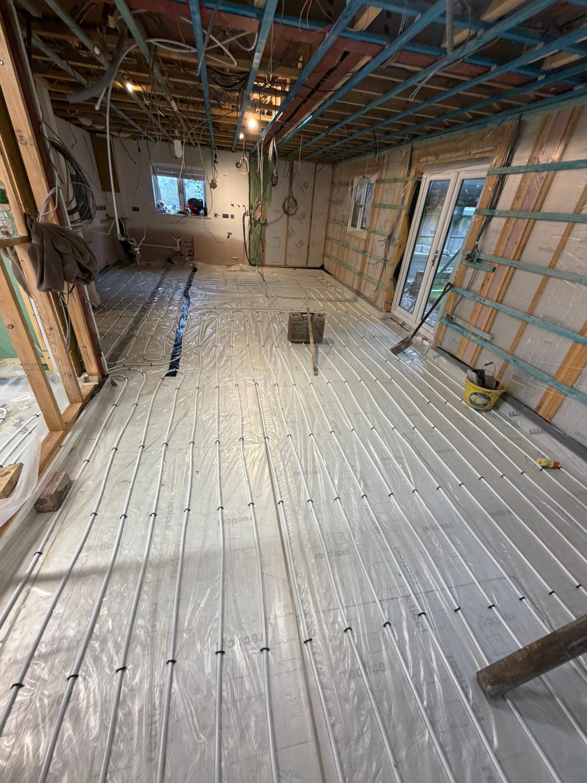 Underfloor heating pipework run over the insulation and separating layer, waiting for the screed