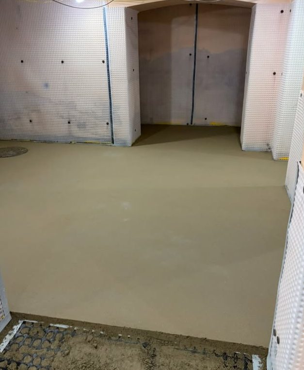 Insulated floor build up screeded over in a tanked basement