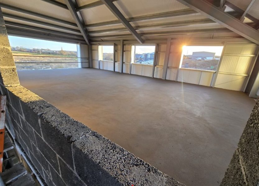 Screeded floor across a steel frame industrial unit at sunset